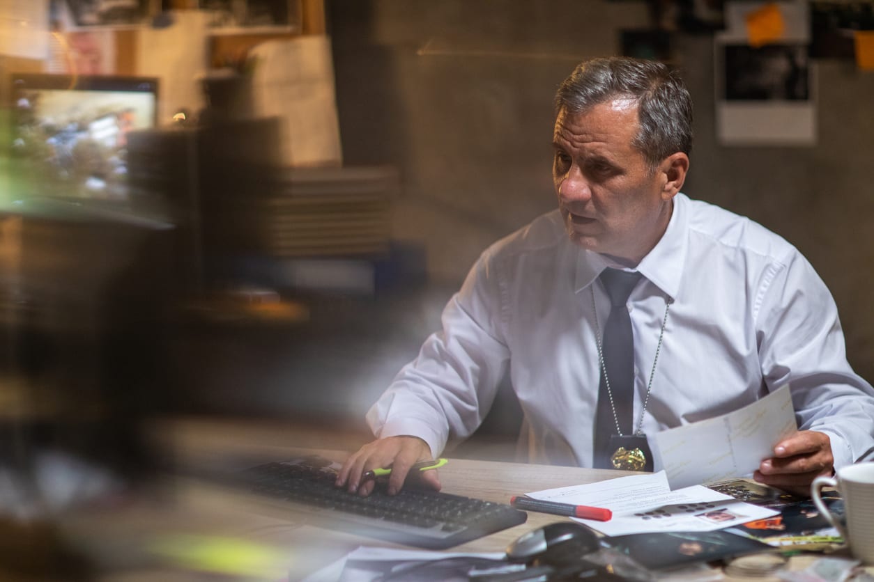 Mature police detective sitting at the desk