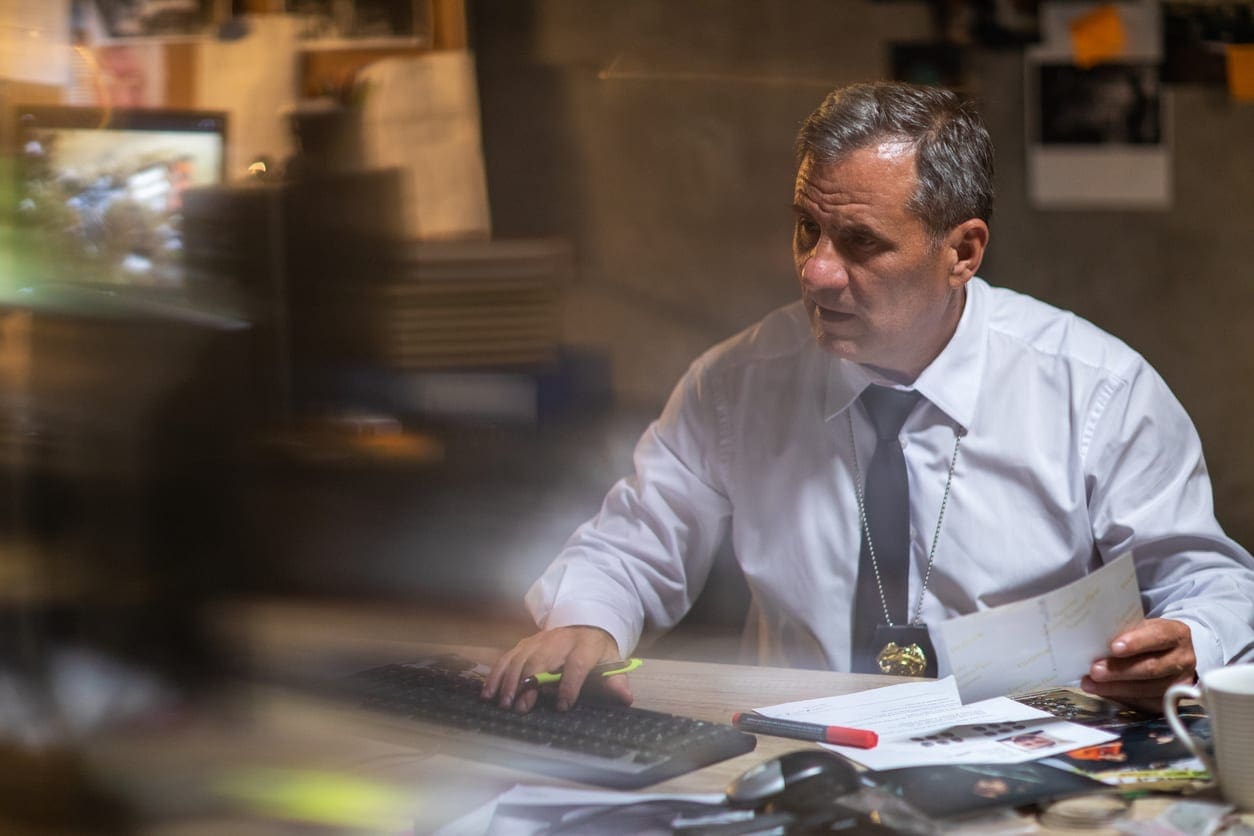 Mature police detective sitting at the desk